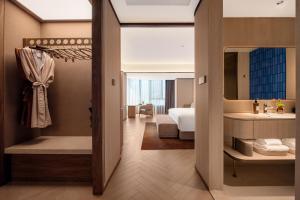 une chambre d'hôtel avec un lit et une salle de bain dans l'établissement Crystal Hotel Qingdao The Mall of Splendors, à Qingdao