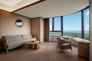 un salon avec un canapé et une table dans l'établissement Crystal Hotel Qingdao The Mall of Splendors, à Qingdao