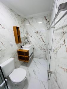 a white bathroom with a toilet and a sink at Cantinho de canela in Canela