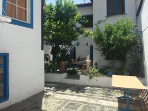 a courtyard of a house with a table and trees at Fındık Pansıyon in İzmir