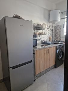 cocina con nevera y lavavajillas en Modern Flat Between Forest, Beach & Airport, en Tánger
