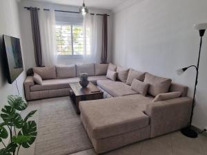 una sala de estar con un sofá y una mesa en Modern Flat Between Forest, Beach & Airport, en Tánger