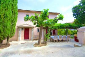 eine Terrasse mit einem Tisch und einem Baum vor einem Haus in der Unterkunft Villa Roca in Les Issambres