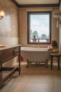 a woman laying in a bath tub in a bathroom at Heritage Line Ginger Cruise - Halong Bay & Lan Ha Bay in Ha Long