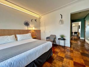 une chambre d'hôtel avec un lit et une chaise dans l'établissement Living Vaisse, à Santiago
