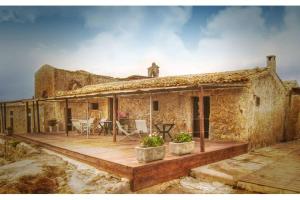a stone house with a porch and a patio at Agosud Casa vacanze in Marzamemi