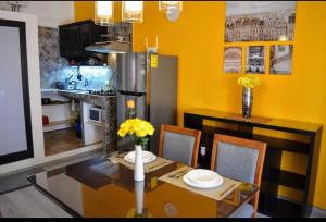 a kitchen with a dining table with yellow walls at Le Chat Noir in Puebla