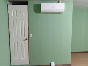 a room with a green wall and a white door at Casa de Huéspedes Noche de Luna in San Salvador