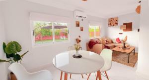 a white living room with a white table and chairs at Villa Dayet Roumi House in Friday Market