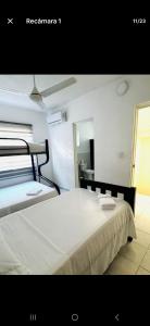 1 dormitorio con 1 cama blanca grande y espejo en Kasa koko, en Cancún