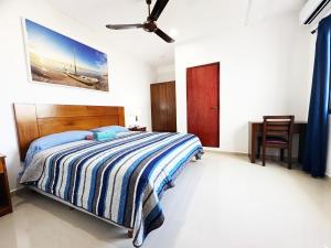 a bedroom with a bed and a ceiling fan at Suites paty de Suites Rocio in Isla Mujeres