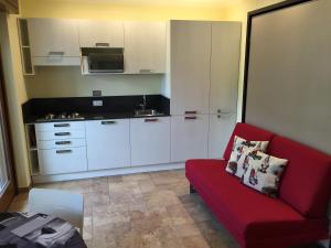 a living room with a red couch and a kitchen at Lo Scoiattolo in Sauze dʼOulx