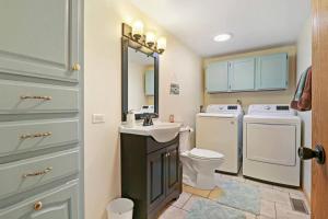 a bathroom with a toilet sink and a washer and dryer at Gorgeous Nautical Lake House Chain O' Lakes with Hot Tub Option 