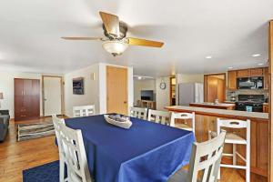 a dining room with a blue table and a kitchen at Gorgeous Nautical Lake House Chain O' Lakes with Hot Tub Option 