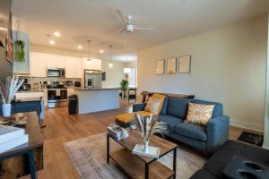 a living room with a blue couch and a kitchen at Wilmingtonbeachmoderncozypooltablefreewifi in Wilmington