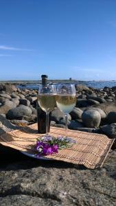 a glass of white wine and flowers on a table at Baviana Beach Lodge in Jacobs Bay