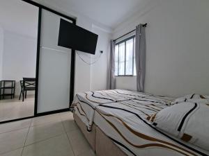 a white bedroom with a bed and a television at San Luis Apartamento 301 Cúcuta in Cúcuta