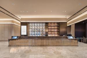 a lobby of a hotel with a bar in it at Orange Crystal Qingdao Taitung Pedestrian Street Hotel in Qingdao