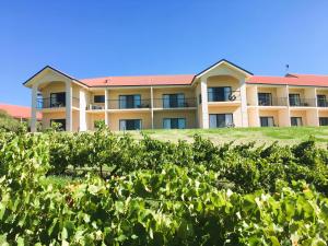 an apartment building behind a hedge of bushes at Turners Vineyard Motel in Orange