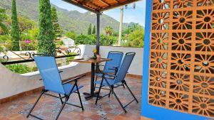 eine Terrasse mit zwei Stühlen und einem Tisch auf einem Balkon in der Unterkunft Casa Axixic in Ajijic