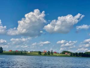 een uitzicht op een meer met een bewolkte lucht bij Domek, caravaning nad jeziorem, Giże in Giże +8 foto's