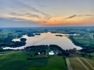 een luchtzicht op een groot meer in een veld bij Domek, caravaning nad jeziorem, Giże in Giże