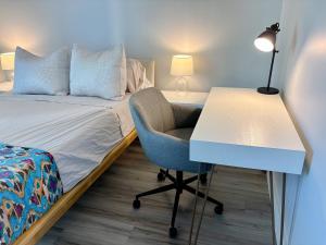 a bedroom with a bed and a desk and a chair at Chic Salt Lake 2-Bedroom FG condo in Honolulu