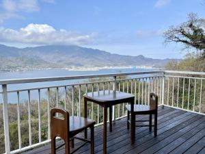 小豆岛The Little Cabin in Shodoshima -小豆島 山小屋 リトルキャビン-的观景甲板上配有一张桌子和两把椅子