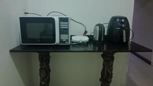 a table with a microwave and a telephone on it at Pousada Vida & Brisa in Pelotas +3 photos