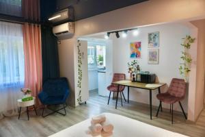 a room with a table and chairs and a kitchen at Eve's Place in Brăila
