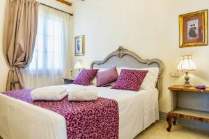 a bedroom with a large bed with purple pillows at Private Villa Among Pine Trees And Lavender in Marina di Grosseto