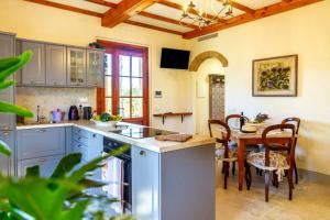 a kitchen with blue cabinets and a table with chairs at Private Villa Among Pine Trees And Lavender in Marina di Grosseto