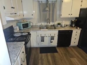 a kitchen with white cabinets and a sink and a microwave at Peace and tranquility in Davenport