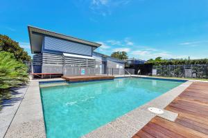 a swimming pool in front of a house at Seaspray Haven, 10 Seaspray Ave - air con, complex pool, Wi-Fi, Linen in Nelson Bay