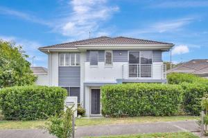 a white house with bushes in front of it at Seaspray Haven, 10 Seaspray Ave - air con, complex pool, Wi-Fi, Linen in Nelson Bay