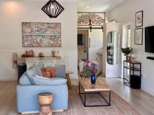 a living room with a blue couch and a table at The Eco Shed - Private Riverfront Getaway - Close to Town - Pet Friendly in Bellingen