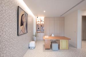 ein Zimmer mit einem Schreibtisch und einem Gemälde an der Wand in der Unterkunft JunSu in Baisha