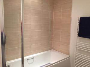 a shower with a glass door and a tub at Edinburgh Western Harbour in Edinburgh