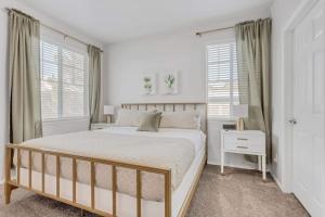 a white bedroom with a large bed and windows at Ground Floor King Beds Pool Gym Near Hill AFB in Clearfield
