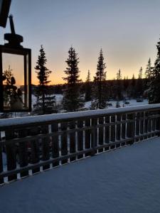 a sunset over a fence in the snow at Traditional Family Cabin Near Rabalen in Bagn