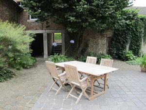 a wooden table and chairs on a patio at lisa's weelde in Tongeren