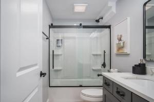 a bathroom with a shower and a toilet and a sink at Harbor Clubhouse Modern Waterfront with Hot Tub and Pet Friendly in Fox Lake