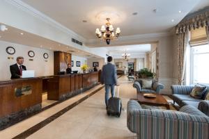 een man met een koffer die door een hotellobby loopt bij Park International Hotel in Londen