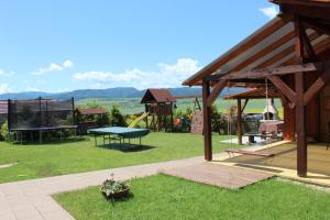 einen Hinterhof mit einem Spielplatz mit einem Tisch und einem Ping in der Unterkunft Penzion Úsmev in Arnutovce