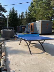 a ping pong table in front of a tiny house at Maringotky Šumava in Sušice