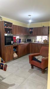 a kitchen with wooden cabinets and a chair in a room at Casita cómoda y de confianza in San Fernando del Valle de Catamarca
