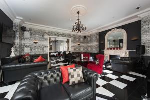 a living room with black leather furniture and a fireplace at Park International Hotel in London