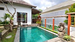 a swimming pool in front of a house at Parigata Classic Home in Dalung