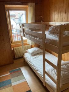 two bunk beds in a room with a window at Gramimmo - Appartement La Cascade in Salvan