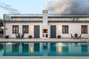 a house with a swimming pool in front of it at Hotell Gässlingen in Skanör med Falsterbo